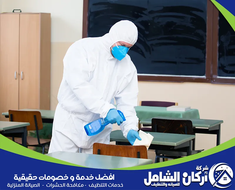 فني تنظيف مدارس بالاحساء يقوم بتنظيف طاولات المدارس بالاحساء وتعقيمها باستخدام المعقمات الفعالة.