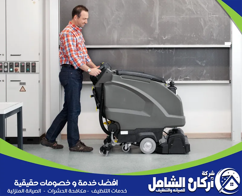 فني شركة maskancare يقوم بتنظيف ارضية الفصول الدراسية بالهفوف باستخدام جهاز تنظيف الارضيات.