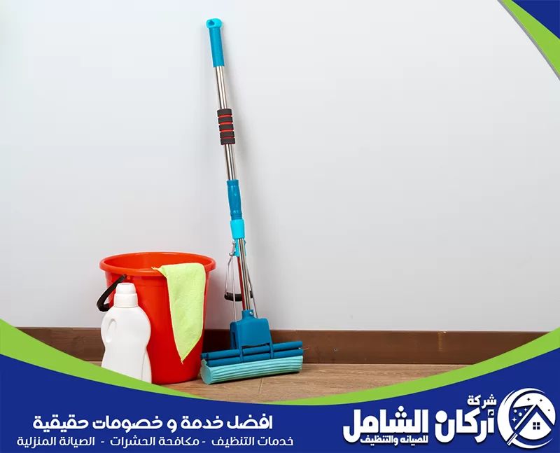 تنظيف الصالة والمجلس ضمن جدول البيت 0500073610 maskancare. دلو وممسحة على أرضية خشبية، في سياق مقال عن جدول تنظيف البيت اليومي والأسبوعي والشهري.