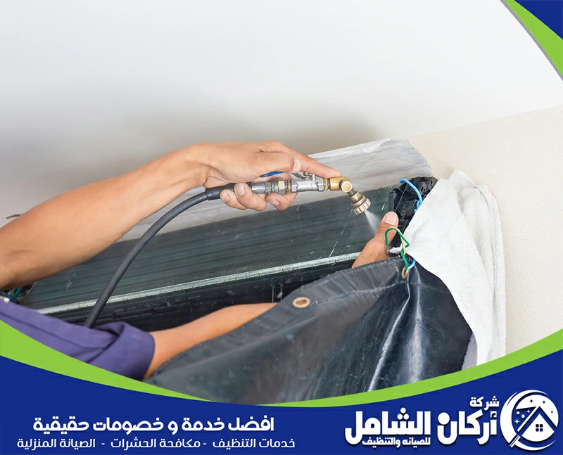 فني مكيفات يستخدم جهاز هواء مضغوط لتنظيف المكونات الداخلية لمكيف الهواء.