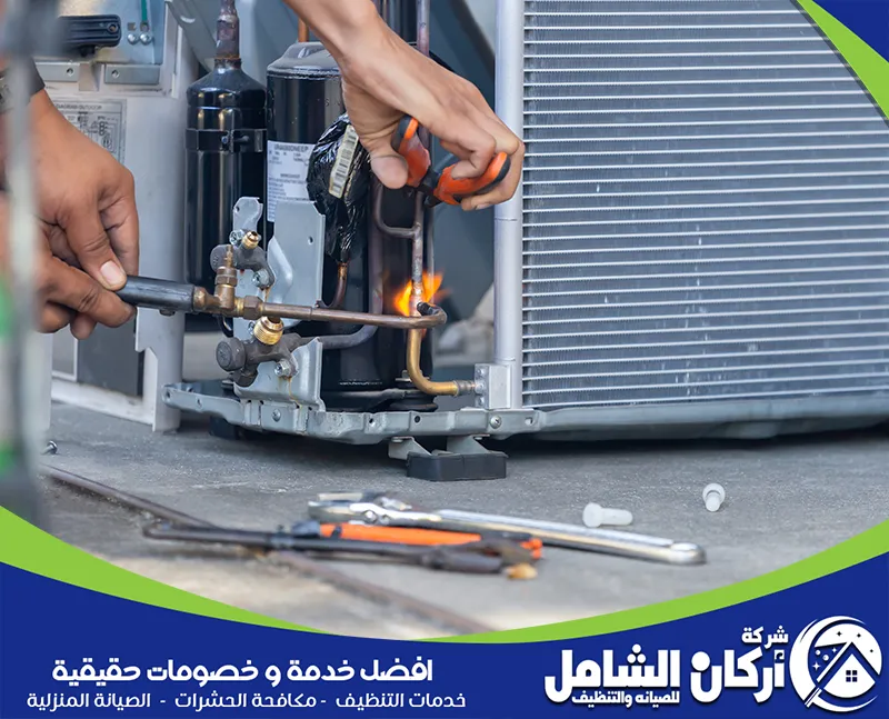 فني يقوم بإصلاح مكيفات باستخدام معدات لحام لربط الأنابيب داخل المكيف بشكل دقيق.