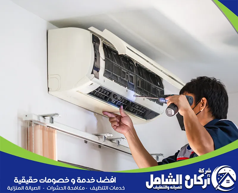 فني متخصص في تصليح مكيفات يقوم بفحص وصيانة المكيف بعناية باستخدام أدواته الخاصة لاستعادة كفاءته العالية 